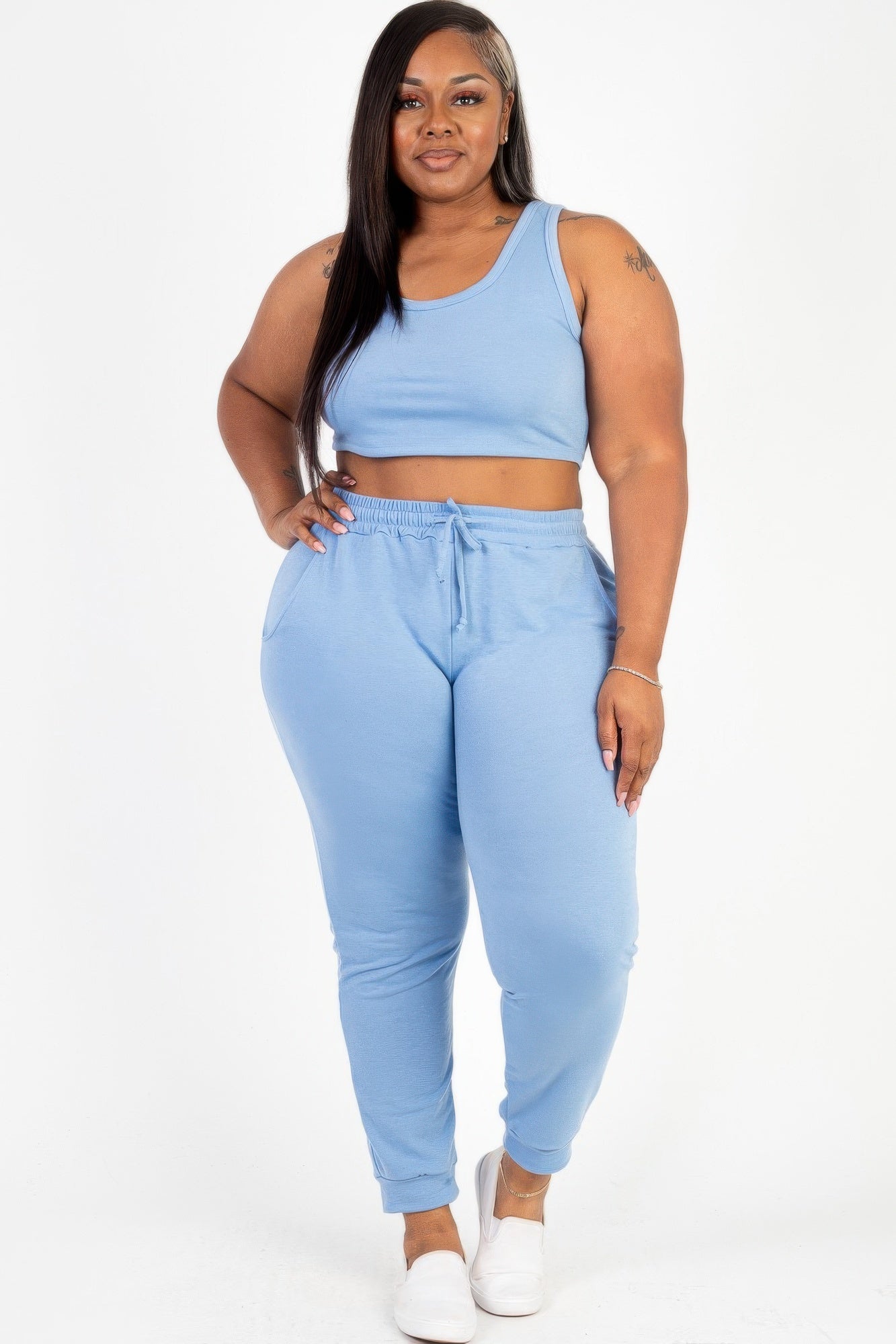 Model posing in a heather gray plus size French terry cropped tank top & joggers set