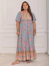  Plus size tie neck maxi dress in a colorful print with flowing flutter sleeves.