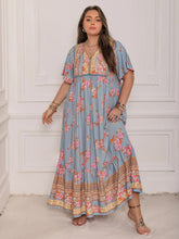  Plus size tie neck maxi dress in a colorful print with flowing flutter sleeves.