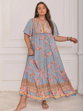  Plus size tie neck maxi dress in a colorful print with flowing flutter sleeves.
