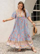  Plus size tie neck maxi dress in a colorful print with flowing flutter sleeves.