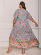  Plus size tie neck maxi dress in a colorful print with flowing flutter sleeves.