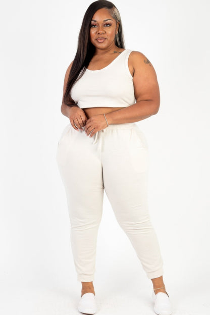  Model posing in a heather gray plus size French terry cropped tank top &amp; joggers set