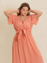  Plus size lace top and skirt set featuring intricate lace paneling and a chic tie neck.