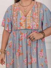  Plus size tie neck maxi dress in a colorful print with flowing flutter sleeves.