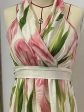 Floral print halter neck maxi dress with a flowing skirt and a vibrant botanical pattern.